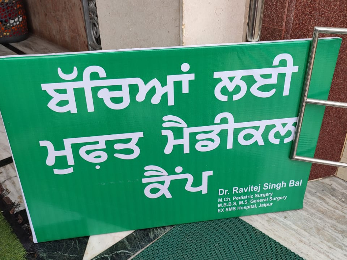 A green banner announcing a free medical camp for children, credited to Dr. Ravitej Singh Bal